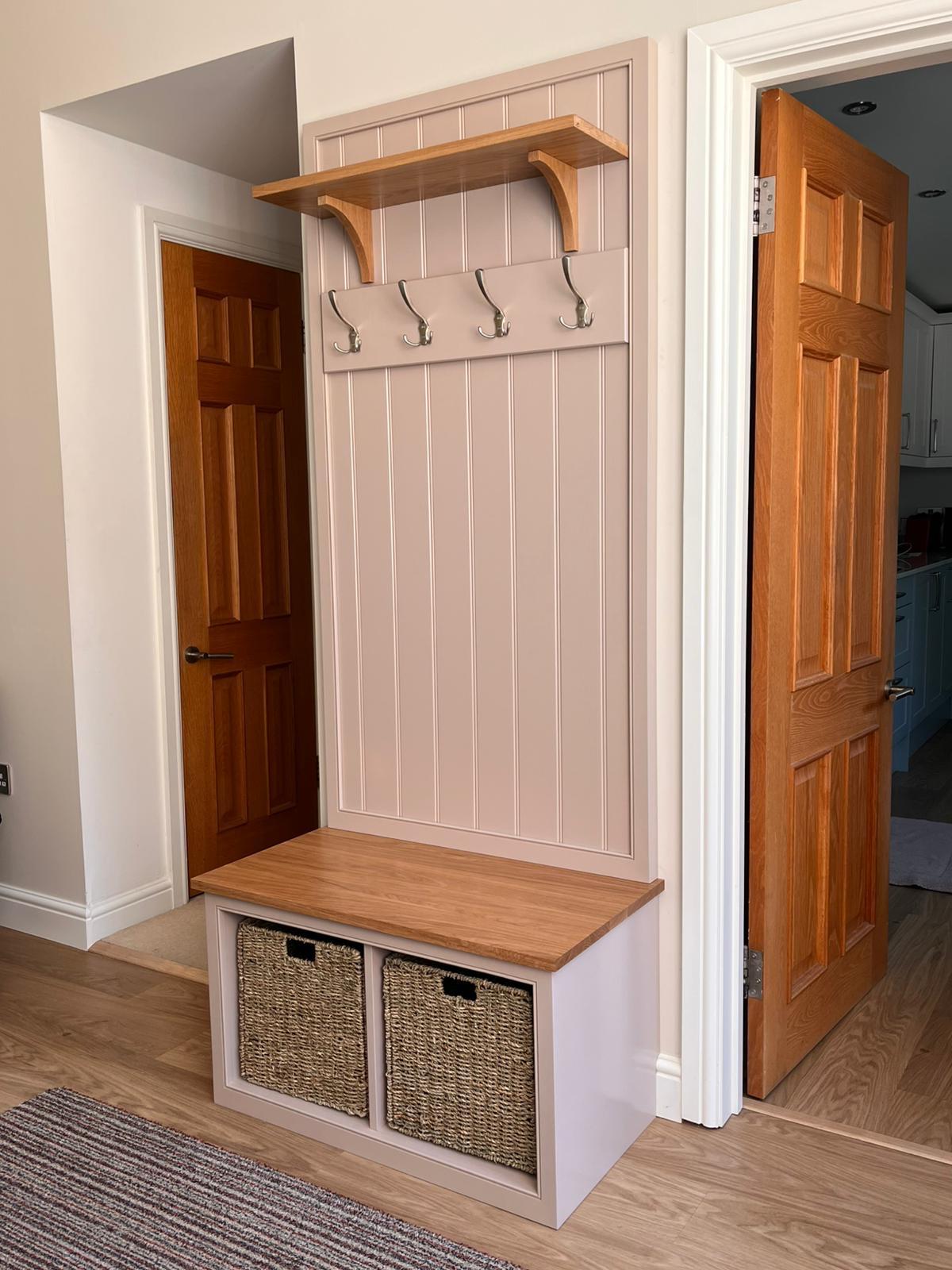 Bespoke boot room bench with tongue-and-groove boarding, coat hooks, oak shelf and basket storage in a hallway